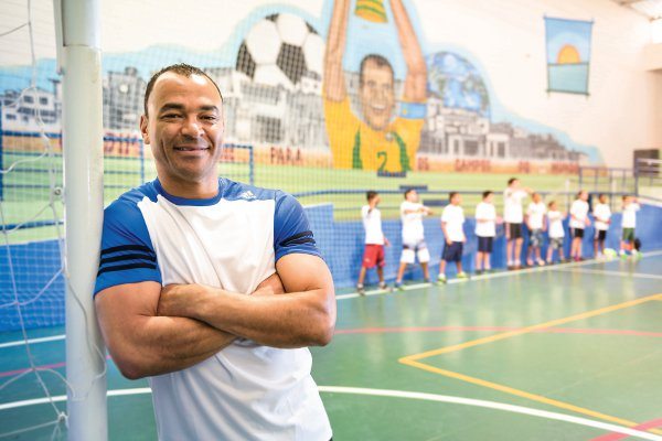 Jogador de Futebol Cafu com crianças ao fundo