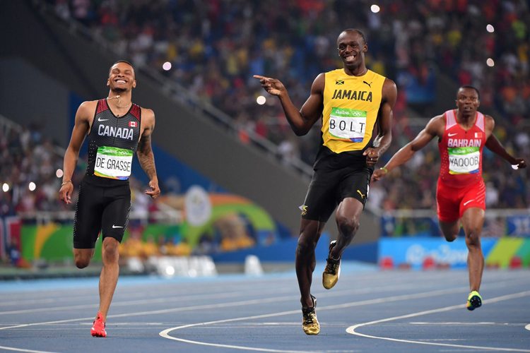 andre de grasse e usain bolt trocam sorrisos no final da prova