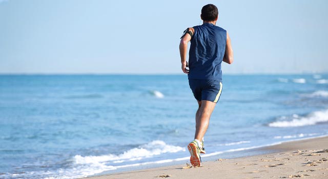 Homem correndo na areia