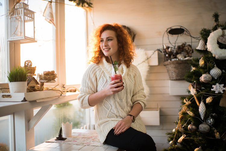 Mulher ruiva tomando um suco em festa de ano novo