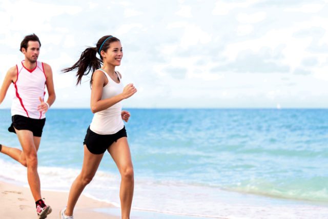 homem e mulher em corrida na praia