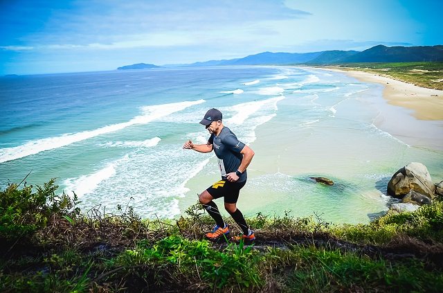 Atleta durante a participação na prova, percorrendo uma trilha em uma montanha da praia do Santinho