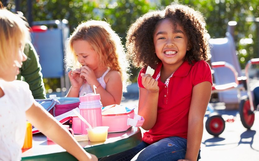Lanches saudáveis para crianças: menina comendo feliz